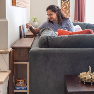 Anika holding charging cord from DIY sofa table with charging station